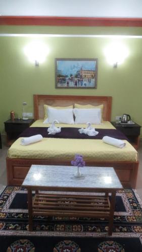 a bedroom with a large bed with a table in it at Mantra Inn Lachung in Lachung