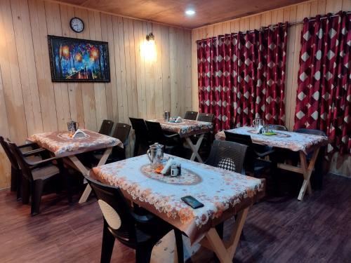 a restaurant with tables and chairs in a room at Mantra Inn Lachung in Lachung