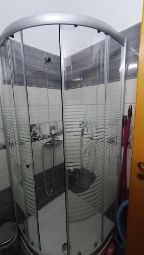 a shower stall with glass doors with a reflection at Nitro Inn Orikum - SEA and GARDEN in Orikum