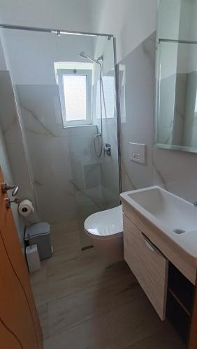 a bathroom with a shower and a toilet and a sink at Nitro Inn Orikum - SEA and GARDEN in Orikum