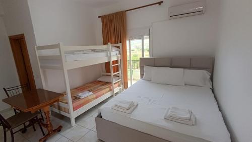 a bedroom with a bunk bed and a desk at Nitro Inn Orikum - SEA and GARDEN in Orikum