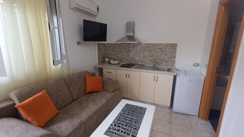a living room with a couch and a kitchen at Nitro Inn Orikum - SEA and GARDEN in Orikum