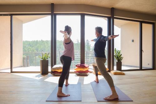 a man and a woman doing yoga in a room at Hotel Seehof Nature Retreat in Naz-Sciaves