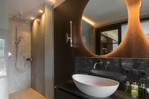 a bathroom with a sink and a shower and a mirror at Hotel Seehof Nature Retreat in Naz-Sciaves