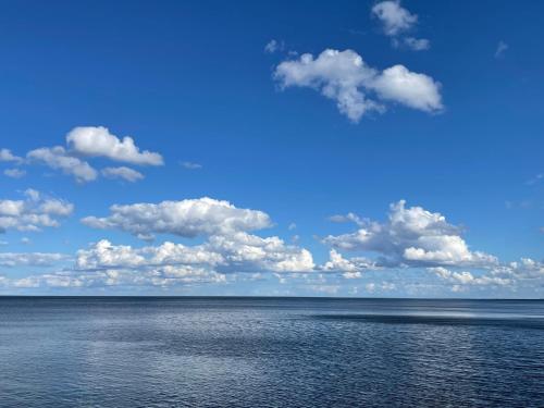 a large body of water with clouds in the sky at Suite am Meer / Seaside suite in Ķesterciems