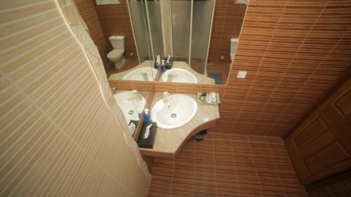 a bathroom with two sinks and a mirror at Four Squares by WI Hotel in Karachi