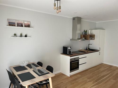 a kitchen and dining room with a table and chairs at Suite am Meer / Seaside suite in Ķesterciems
