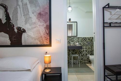 a bedroom with a bed and a bathroom at SMART Rooms Pistoia in Pistoia