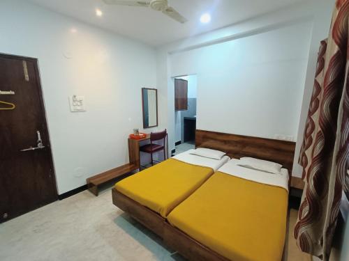 a bedroom with a yellow bed in a room at Hotel Parth Residency in Kolhapur