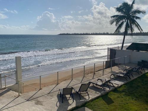 a group of chairs sitting on the beach at Oceanfront Condo in Luquillo in Luquillo