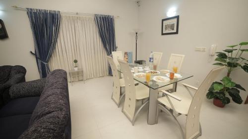 a living room with a dining room table and chairs at Four Squares by WI Hotel in Karachi
