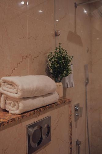 ein Bad mit einer Dusche und Handtüchern auf der Theke in der Unterkunft The Novello by Evergreen Mussoorie in Masuri