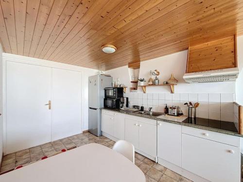 une cuisine avec des armoires blanches et un plafond en bois dans l'établissement Le Nid Marin - Sea View - 3 Br, à Dunkerque
