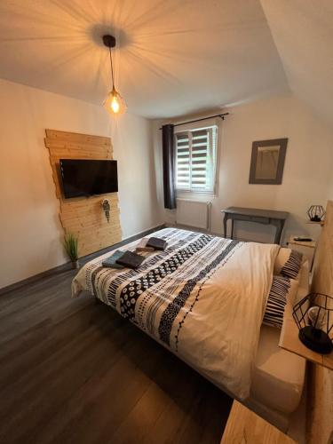 une chambre avec un grand lit et une télévision dans l'établissement L'écluse des Fontinettes, maison de ville atypique, à Arques