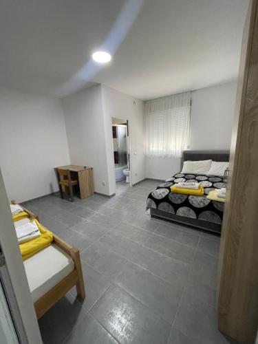 a bedroom with two beds and a table in it at Vile Jana in Leskovac