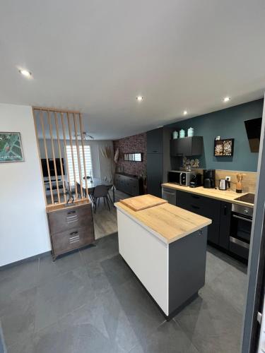 une cuisine avec un comptoir et une salle à manger dans l'établissement L'écluse des Fontinettes, maison de ville atypique, à Arques