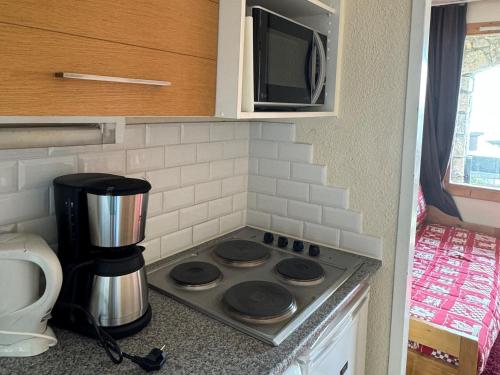 Il comprend une cuisine équipée d'une cuisinière et d'un four micro-ondes. dans l'établissement Appartement confortable au pied des pistes avec balcon et parking - FR-1-181-2055, à La Plagne Tarentaise