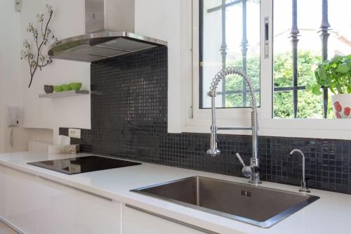 une cuisine avec un évier en acier inoxydable et une fenêtre dans l'établissement Spacious Villa Vallauris Cannes with AC throughout and large private pool, à Vallauris