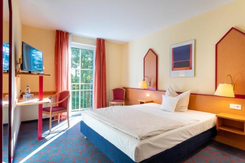 a hotel room with a bed and a desk at Montana Hotel Senden in Senden