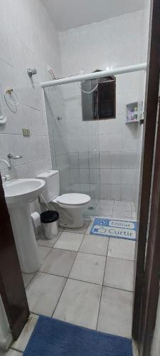 a bathroom with a toilet and a sink at Sua casa longe de casa in Mongaguá