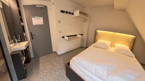 a small bedroom with a bed and a sink at Das Kittchen in Wismar
