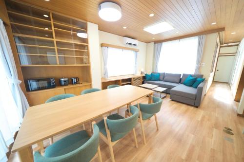 a room with a table and chairs and a couch at FINOA Penthouse Suite Ikebukuro Sunshine in Tokyo