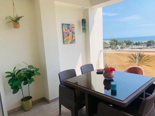 a table and chairs in a room with a window at Panorama Apartment Zone Touristique Haut Standing in Mahdia