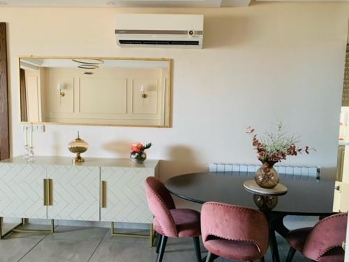 a kitchen with a table and some pink chairs at Panorama Apartment Zone Touristique Haut Standing in Mahdia