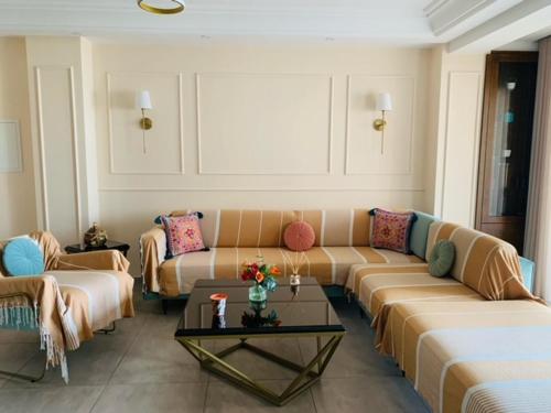 a living room with couches and a coffee table at Panorama Apartment Zone Touristique Haut Standing in Mahdia