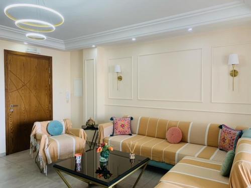 a living room with a couch and a table at Panorama Apartment Zone Touristique Haut Standing in Mahdia