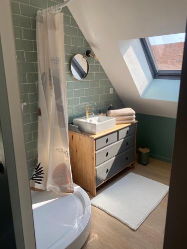La salle de bains mansardée est pourvue d'un lavabo et de toilettes. dans l'établissement Petite maison de bourg, à Noyers