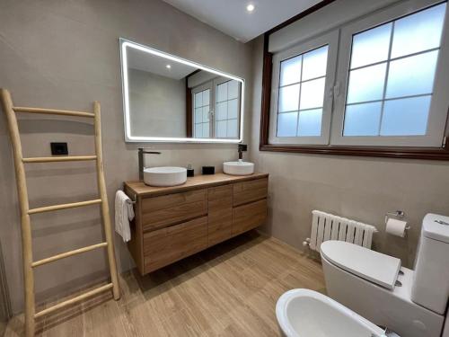 ein Badezimmer mit zwei Waschbecken und einem Spiegel in der Unterkunft CasaPlayaPatos,com Panxón in Nigrán