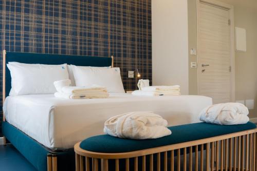 a bedroom with a bed with towels on a bench at EKOA comfort e relax in San Nicola Arcella