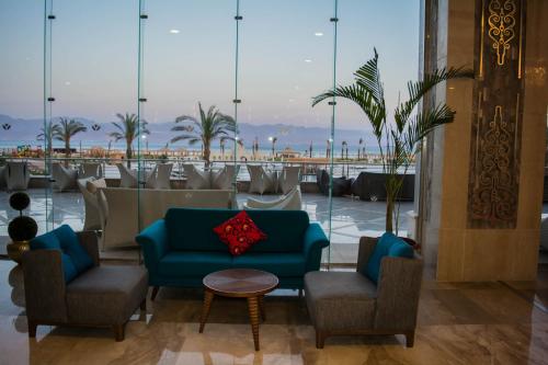 a lobby with a blue couch and chairs at Tolip Taba Resort And Spa in Taba