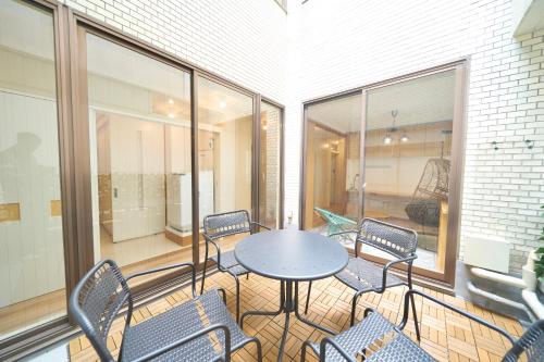 a room with a table and chairs on a balcony at FINOA Penthouse Suite Ikebukuro Sunshine in Tokyo