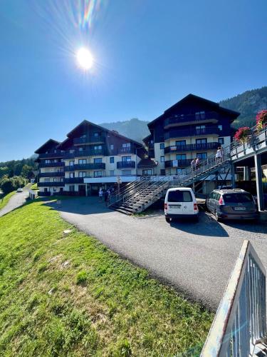 une voiture garée dans un parking à côté d'un bâtiment dans l'établissement Appartement Perce-Neige, à Thollon-les-Mémises