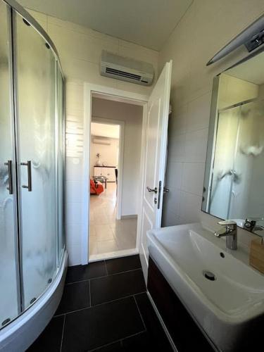 a bathroom with a sink and a shower and a mirror at Oleander in Podstrana