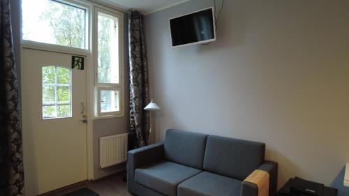 a living room with a couch and a tv on the wall at Lapin Satu in Posio