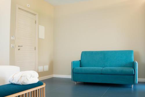 a blue chair sitting in a living room with a table at EKOA comfort e relax in San Nicola Arcella