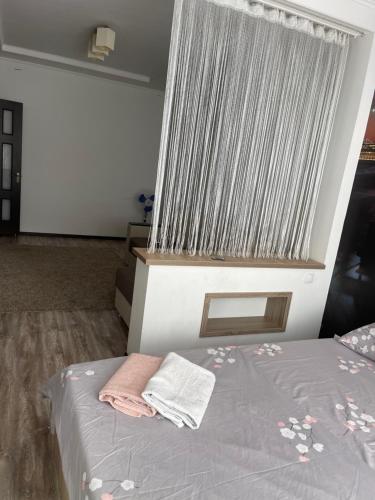 a bedroom with a bed with a large window at Уютная квартира in Chişinău