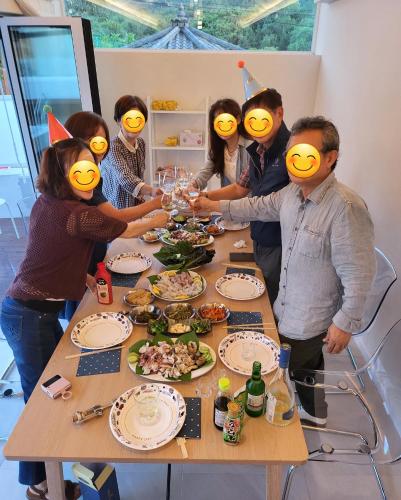 a group of people wearing face masks standing around a table at Ido Stay in Samcheok