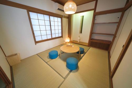 a room with a table and some blue stools at FINOA Penthouse Suite Ikebukuro Sunshine in Tokyo