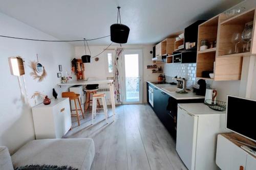 une cuisine avec des armoires blanches et une table et des chaises dans l'établissement Charmant appartement calme avec terrasse, à Montrouge