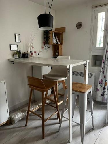- une table et des chaises blanches dans la chambre dans l'établissement Charmant appartement calme avec terrasse, à Montrouge