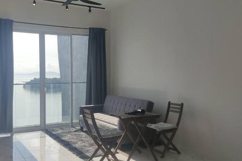 a table and chairs in a room with a window at Penang Seaview Apartment up to 11 pax in Bayan Lepas
