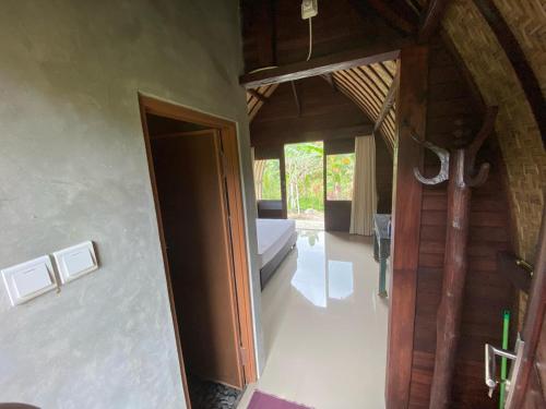 Zimmer mit einem Bett und einem Zimmer mit einem Eingang in der Unterkunft Babakan Unda Cottage in Semarapura