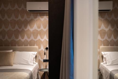 a bedroom with two beds and a wall with hearts at Amphora Nafplio- elegance Suites Apartmenthouse in Nafplio