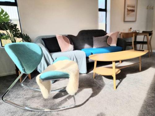 a living room with a couch and chairs and a table at Addington Townhouse 7 mins walk to Arena in Christchurch