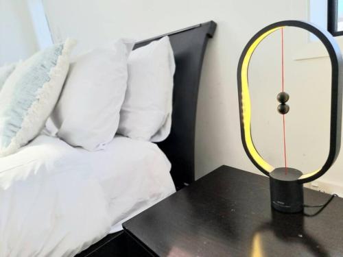a lamp on a table next to a bed at Addington Townhouse 7 mins walk to Arena in Christchurch