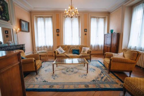 ein Wohnzimmer mit Sofas und einem Couchtisch in der Unterkunft L'Écrin - Stationnement Privatif - Coeur de ville in Châteauroux